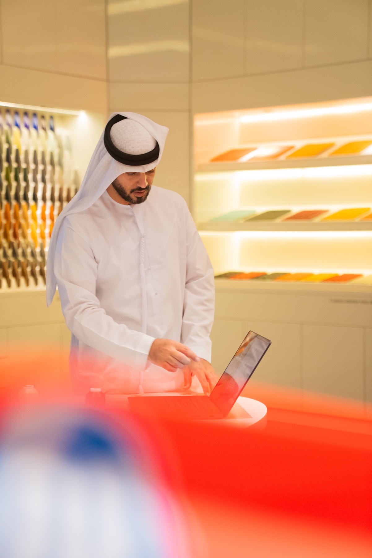 Fawaz M. Khalid working with a tablet in a materials showroom